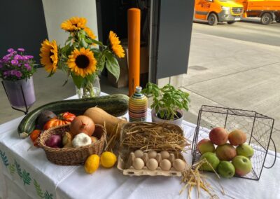 Erntedank-Tisch mit Gemüse, Eiern, Äpfeln und Sonnenblumen